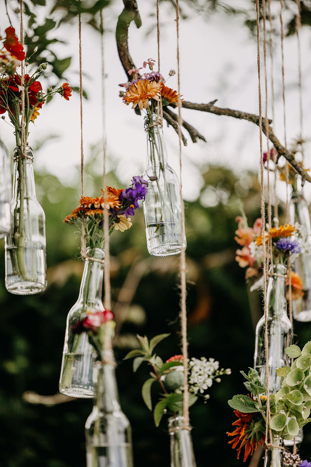Hangende bloemenvaasjes in boom - inkleding huwelijk